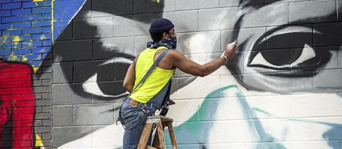 An artist paints a mural celebrating the heroism of Chicago's pandemic first responders