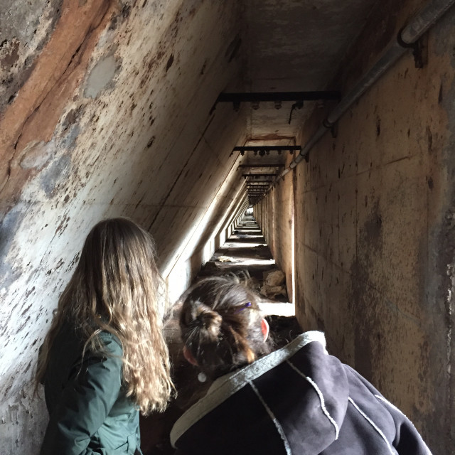 Students explore inside the ore wall at the historic Southworks site in South Chicago