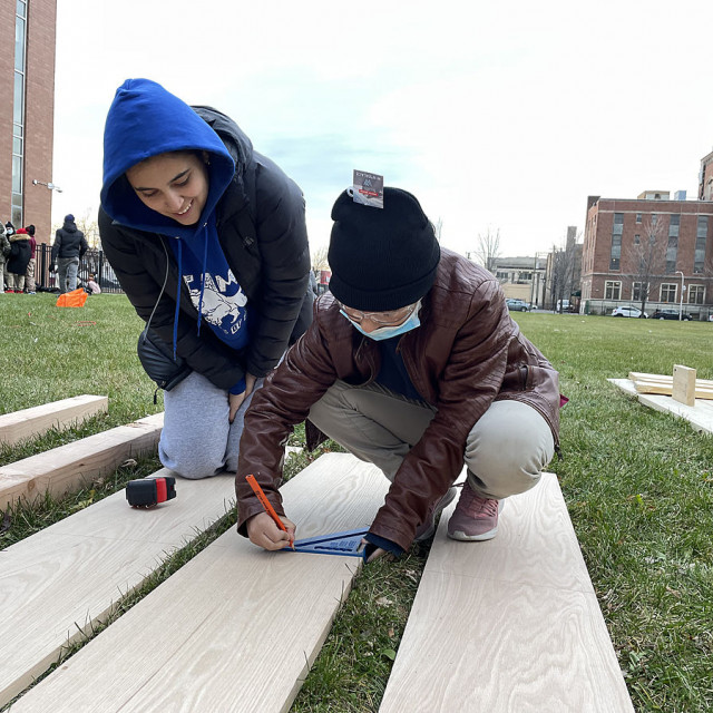 A College student works with a Claremont Academy 6th grader to create prototype playground equipment.